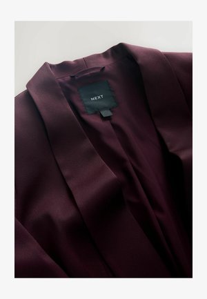 Donkerpaarse blazer met zichtbare kraag en zwart label met witte "NEXT" merknaam aan de binnenkant van de hals.