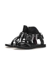 Sandalias de cuero negro con correas en el tobillo, detalles de flecos de metal plateado, puntas abiertas y suelas planas, exhibidas sobre un fondo blanco.