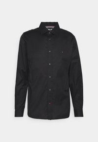 Czarna, długosmykowa koszula z gładkiej bawełny. Posiada kołnierzyk zapinany na guziki, guziki z przodu oraz małe logo wyszyte na klatce piersiowej.