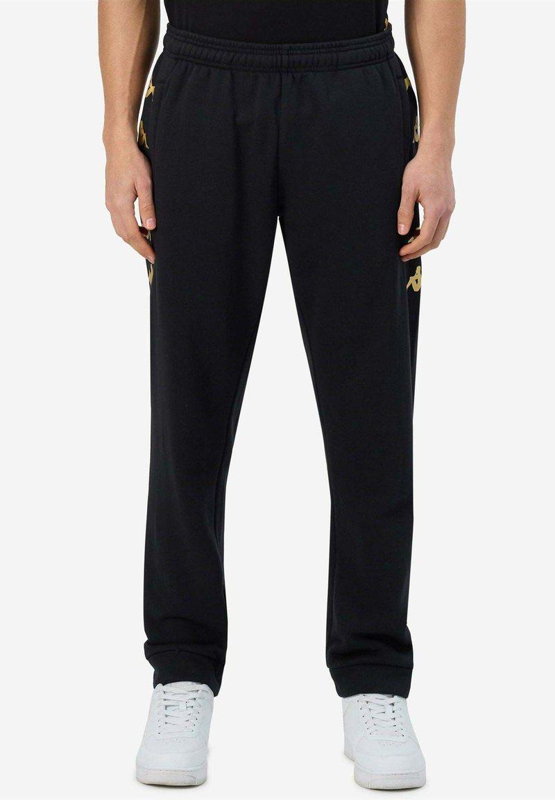 Zwarte sportbroeken met een elastische tailleband, zijzakken en gele logo-accenten. Gemaakt van zachte, rekbare stof voor comfort.