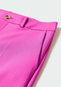 Pantalones fucsias con una textura suave, que cuentan con un pleat delantero, trabillas para cinturón y un cierre de botón en tono dorado en la cinturilla.