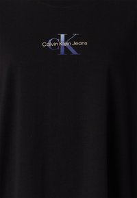 T-shirt en coton noir avec un logo "Calvin Klein Jeans" multicolore en bleu et or, avec une coupe décontractée et un col rond.