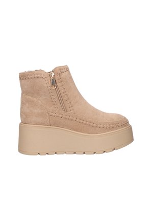 Botas de tobillo de ante beige con suela de plataforma, cierre lateral con cremallera y costuras decorativas a lo largo de los bordes. Forro interior de textura suave.