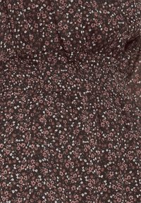 Blumenmusterkleid mit einem dunkelbraunen Grundton. Verziert mit kleinen rosa und weißen Blumen, hat einen elastischen Bund und eine geraffte Textur mit einem fließenden Design.