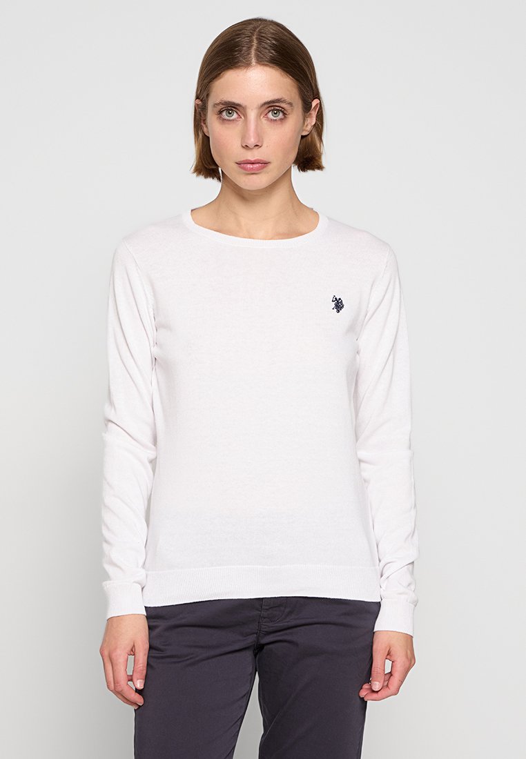 Weißer Pullover mit langen Ärmeln und geripptem Halsausschnitt sowie Bündchen, mit einem kleinen Marineblauen Logo auf der linken Brust. Weicher, leichter Stoff.