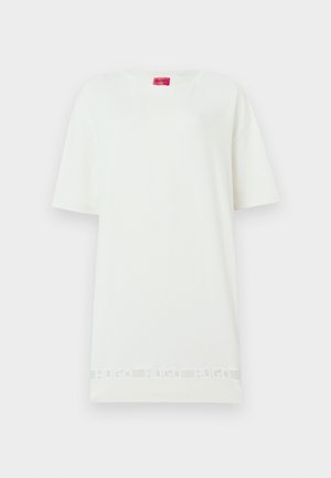 Tricou alb supradimensionat cu mâneci scurte, guler rotund, etichetă roșie la guler și o bandă discretă cu textul „HUGO” aproape de tiv.