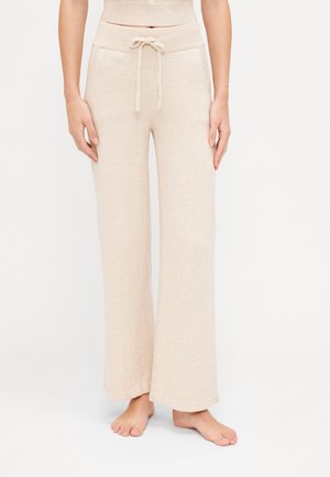 Beige wide-leg pants made of soft fabric, featuring a drawstring waist and ribbed details. Includes two side pockets.