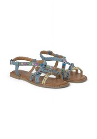 Blauwe denim sandalen met gevlochten banden, kleurrijke versieringen en een platte bruine zool met decoratieve studs langs de randen.