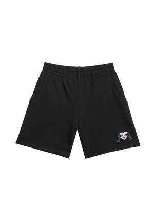 Młoda dziewczyna z długimi blond włosami, ubrana w fioletowy top bez rękawów, czarne szorty, białe skarpetki, czarno-białe trampki i pastelową czapkę założoną do tyłu.