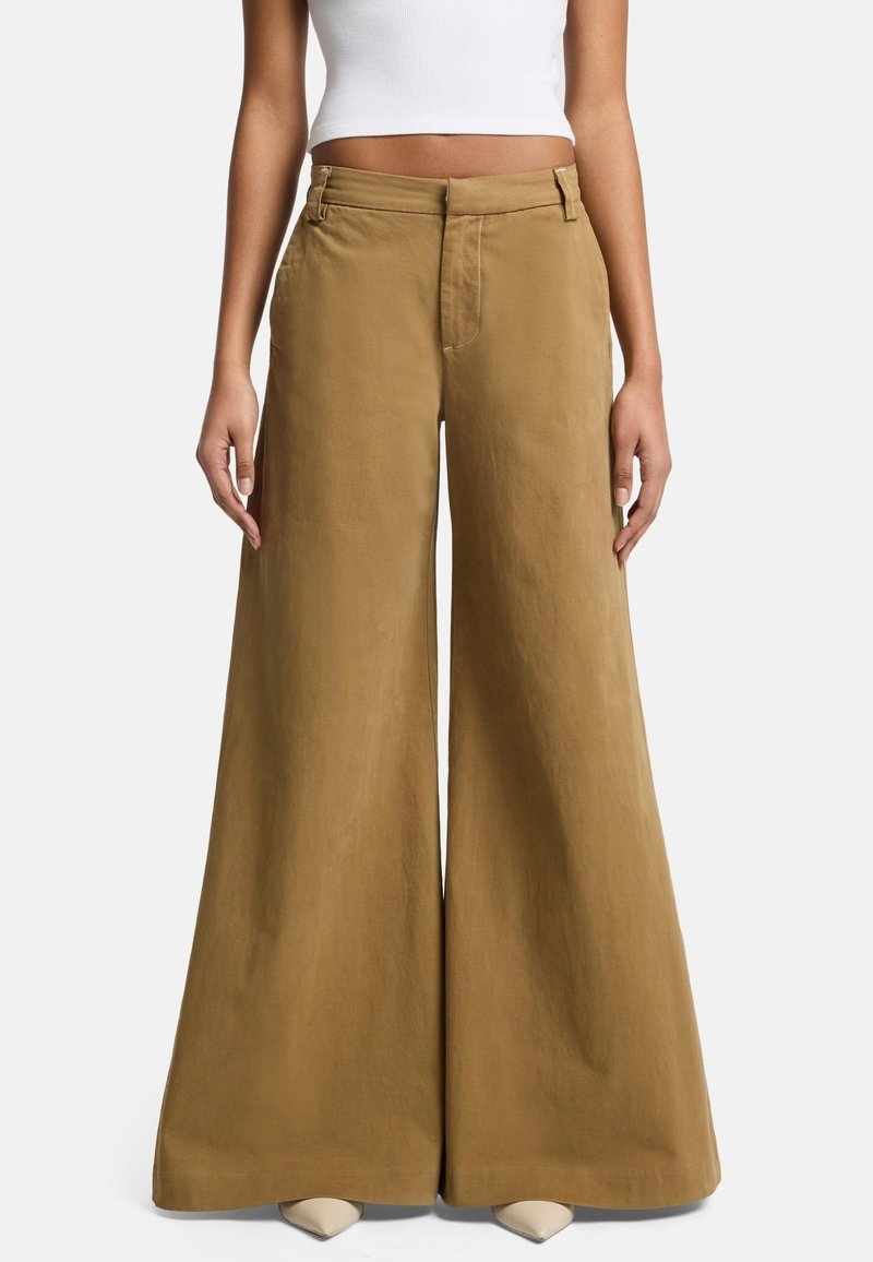 Pantaloni a gamba larga in tessuto marrone chiaro, con vita alta e passanti per cintura, dal texture morbido e leggermente lucido.