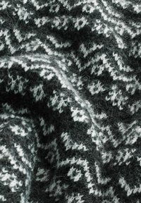 Țesătură tricotată de culoare gri închis cu un model geometric alb. Textura este moale și pufoasă, evidențiind o structură densă și călduroasă.