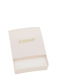 Liten vit rektangulär låda med ett något öppet lock, med ordet "amor" i guld centrerat på toppen.