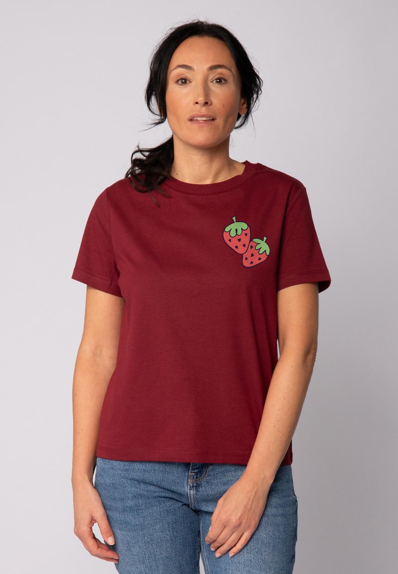 T-shirt en coton bordeaux à manches courtes, col rond, présentant deux motifs de fraises accentués de vert sur la poitrine gauche.