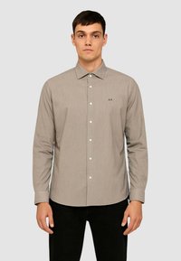 Camicia a maniche lunghe con bottoni in tessuto beige chiaro a righe orizzontali, dotata di colletto standard e piccolo logo "AX" sopra la tasca sinistra del petto.