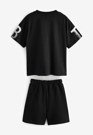 Ensemble en coton noir composé d'un t-shirt à manches courtes avec des accents graphiques sur les manches et un short à taille élastique.
