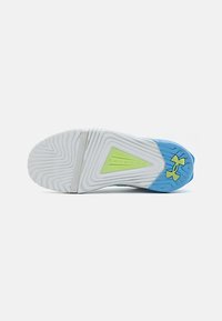 Talpa de pantof sport alb și albastru cu un model de profil, inserție triangulară verde etichetată "TRIBYSE" și logo-ul Under Armour pe călcâi.