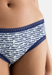 Marineblauwe en lichtblauwe onderbroek met een gekleurde patroontje en kantafwerking langs de tailleband, met een zachte textuur en een aangesloten pasvorm.