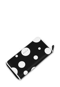 Černá peněženka s bílými puntíky a bílým zipem, uvnitř s názvem značky "VUCH" vytištěným v kulatém designu. Hladký povrch.
