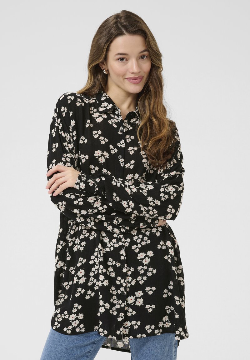 Schwarze Hemdbluse mit einem floralen Muster in Weiß und Rosa, langen Ärmeln und einem lockeren Schnitt, aus leichtem Material gefertigt.