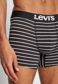 Svarta och vita randiga Levi's boxershorts med en mjuk elastisk midjeband, utrustade med en sydd design och en tät passform runt låren.