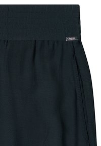 Gros plan d'un tissu noir avec une ceinture cousue et une petite étiquette de marque argentée rectangulaire sur le côté droit.