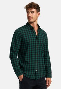Zeleno-černá kostkovaná flanelová košile s límečkem na knoflíky, dlouhými rukávy a dřevěnými knoflíky; pohodlný design a měkká textura.