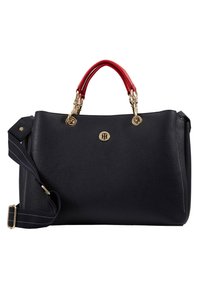 Granatowa skórzana torebka z czerwonymi uchwytami, złotymi elementami wykończenia i odczepianym paskiem. Posiada emblemat z logo oraz subtelne białe przeszycia.