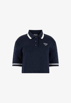 Polo bleu marine avec un motif texturé, manches courtes, accents blancs sur le col et les manches, arborant un logo de marque sur la poitrine.