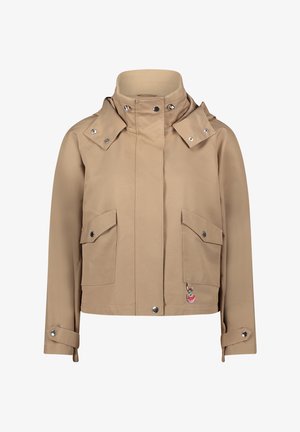 Beige waterdichte jas met een hoge kraag, twee voorzakken, drukknoopsluiting en een decoratieve hangers aan de linkerzak.