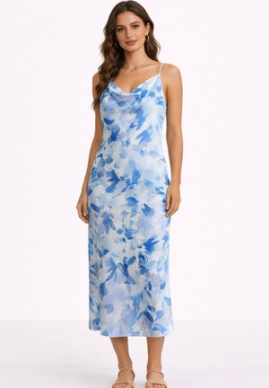 Femme portant une robe sans manches, longue jusqu'aux chevilles, avec un motif floral abstrait bleu et blanc, se tenant avec les bras détendus le long du corps.