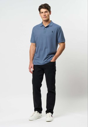 Meeste lühikeste varrukatega polo-särk tahma sinist tooni, valmistatud puuvillasegust, millel on soonikuga krae ja vasakul rinnal peen logo; kombineeritud mustade pükstega.