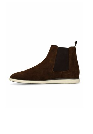 Bruine suède Chelsea-laars met een zwart elastisch zijpaneel en witte rubberen zool, gezien vanaf de buitenkant.