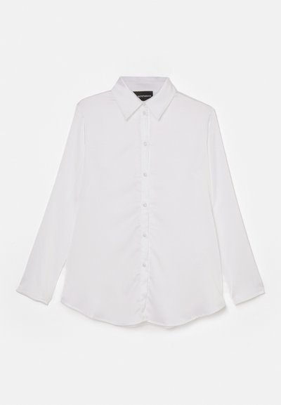 Bílá dlouhá košile s dlouhým rukávem, s knoflíkovým zapínáním vpředu, klasickým límečkem, hladkým povrchem, zakřiveným spodním lemem a jemným leskem.