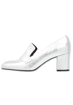 Mocassini con tacco argento, finitura metallica liscia, punta appuntita e una larga fascia sulla parte superiore. Tacco a blocco per maggiore stabilità.
