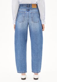 Helle blaue High-Waist-Jeans mit lockerer Passform, ausgestattet mit zwei Gesäßtaschen und einem Leder-Label-Patch am Bund.