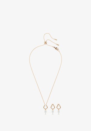 Collar de oro rosa con cadena ajustable y pendientes a juego, cada uno con eslabones circulares y piedras preciosas transparentes en forma de lágrima.