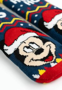 Calze a tema natalizio in blu navy con grafiche a maglia di un topo sorridente con un cappello da Babbo Natale rosso, accenti colorati e motivi a zigzag.