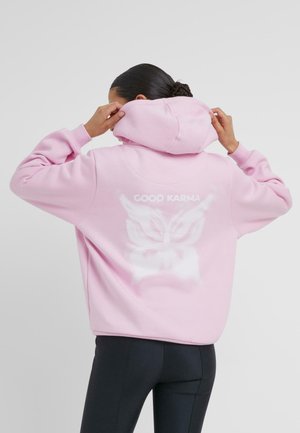 Rosa Kapuzenpullover mit lockerer Passform, der den Schriftzug "GOOD KARMA" und ein Schmetterlingsdesign auf der Rückseite zeigt. Weiche Textur, lässiger Stil.