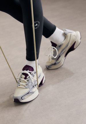 Chaussures de sport légères en blanc cassé avec des accents gris et bourgogne. Tige en mesh, semelle amortissante et lacets pour un maintien sécurisé.