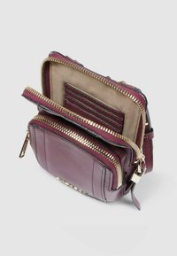 Borsa a tracolla in pelle bordeaux con cerniera, fodera beige a contrasto, più scomparti e dettagli in metallo dorato. Include scomparti per carte.
