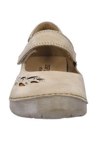 Zapato de cuero beige con puntera redonda, correa de Velcro y diseños florales troquelados que exponen acentos naranjas. Suela texturizada para agarre y comodidad.
