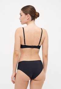 Fekete bikini szett, állítható pántos, kapcsos bralette-tel, amelyet magas derekú alsó résszel párosítottak. Simább, matt textúra.