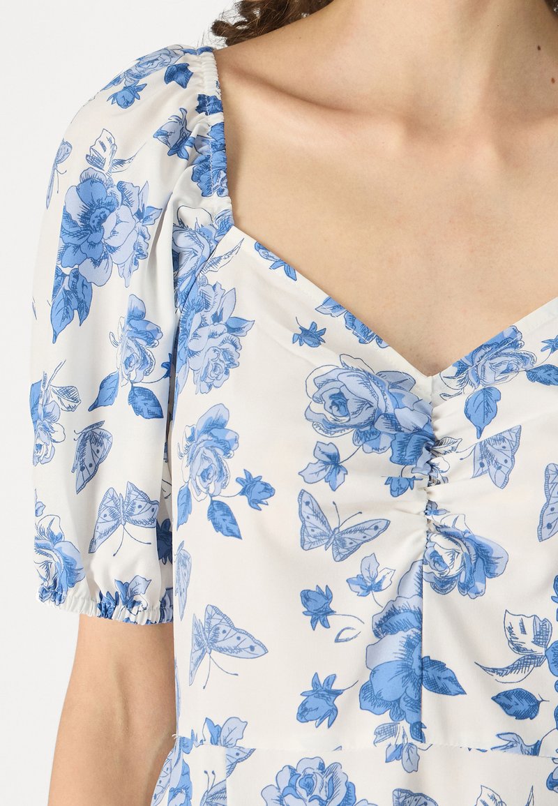 Robe à manches courtes en tissu léger avec un motif floral bleu, dotée d'un décolleté carré et de détails froncés au niveau de la poitrine.