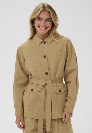 Kurtka koszulowa w kolorze khaki wykonana z wytrzymałej bawełny, z przodem zapinanym na guziki, dwoma kieszeniami na piersi, paskiem w talii i klasycznym kołnierzem.