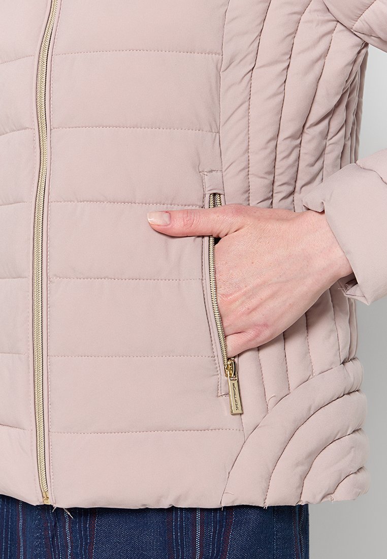 Giacca a vento rosa chiaro con trapuntatura orizzontale, zip dorata e tasche laterali. Tessuto liscio e design aderente con dettagli di cucitura sottili.