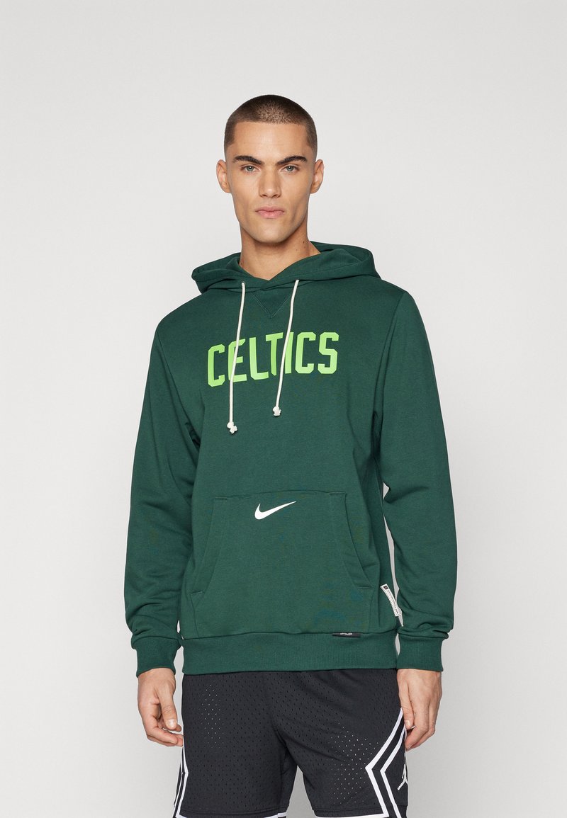 Sweatshirt verde com capuz, com "CELTICS" em letras verdes brilhantes, um bolso frontal e logo da Nike; tecido em mistura de algodão, cordão ajustável.