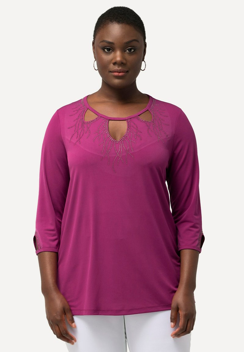 Top fucsia a tre quarti con scollatura a chiave, decorato con dettagli metallici e sottili motivi a foglia sul corpetto.