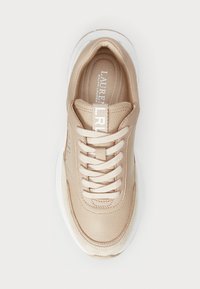 Baskets beiges avec un dessus en cuir texturé, bout rond et lacets de couleur claire. Semelle intermédiaire blanche avec un détail de logo sur la langue.