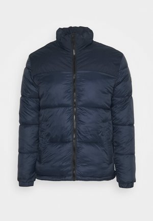 Giacca imbottita trapuntata blu navy con collo alto e cerniera frontale nera, dotata di tasche laterali e maniche lunghe.