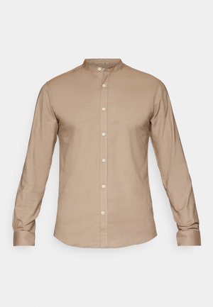 Beige skjorte med krave og lange ærmer, knapfront og en glat tekstur. Har en subtil glans, standardmanchetter og ingen mønstre.